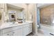 Well-lit bathroom with double sinks, white cabinetry, and a tiled shower/tub combo at 3297 N Duquesne Way, Aurora, CO 80019