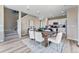 Bright dining area features modern lighting, wood floors, stairs, and an open-concept flow into the kitchen at 3297 N Duquesne Way, Aurora, CO 80019