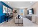 Vibrant game room features a blue accent wall, gaming consoles, and a comfortable seating area at 3297 N Duquesne Way, Aurora, CO 80019