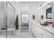 Bright bathroom featuring a large mirror, double vanity, and glass-enclosed shower at 138 S Seacrest St, Golden, CO 80401