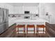 Modern kitchen with stainless steel appliances, white cabinets, a large center island, and stylish pendant lighting at 138 S Seacrest St, Golden, CO 80401