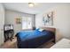 Comfortable bedroom features modern art, a decorative table, and a blue bed by a window at 16019 E Elk Dr, Denver, CO 80239