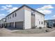 Exterior of a modern townhouse with white siding, a gray garage door, and rock landscaping at 16019 E Elk Dr, Denver, CO 80239