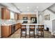 Well-lit kitchen includes wood cabinetry, an island with seating, and modern appliances at 16019 E Elk Dr, Denver, CO 80239