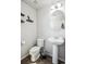 Stylish powder room with pedestal sink, round mirror, and decorative shelves with charming accents at 16019 E Elk Dr, Denver, CO 80239