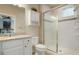 Well-lit bathroom featuring a glass-enclosed shower, tile accents, and a modern vanity at 15345 W 64Th Ln # 107, Arvada, CO 80007