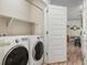Bright laundry room featuring modern appliances and convenient shelving for storage at 15345 W 64Th Ln # 107, Arvada, CO 80007