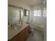 Bright bathroom with a single sink vanity, tub, and window providing natural light at 12235 E 2Nd Dr, Aurora, CO 80011