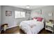 Cozy bedroom with hardwood floors, window and ceiling fan with a white metal frame bed, perfect for relaxation at 1733 S Urban Way, Lakewood, CO 80228