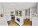 Well-lit kitchen featuring white cabinetry, stainless steel appliances and a functional island at 1733 S Urban Way, Lakewood, CO 80228
