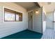 Enclosed balcony area featuring wood decking, windows, and an exterior door at 3049 E Long S Cir, Centennial, CO 80122