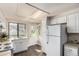 Bright kitchen with white cabinetry and modern appliances has an exterior door at 3049 E Long S Cir, Centennial, CO 80122