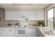 Well-lit kitchen features ample counter space, white cabinetry, and a stylish backsplash at 3049 E Long S Cir, Centennial, CO 80122