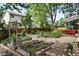 A large backyard features a wood fence, gravel walkways, garden boxes, and a covered red patio at 823 Timothy Dr, Longmont, CO 80503