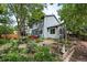 Landscaped backyard featuring a well-maintained lawn, garden beds, and mature trees, creating a private oasis at 823 Timothy Dr, Longmont, CO 80503