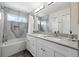 Modern bathroom with double sinks, white cabinets, a marble countertop, and a shower-tub combo at 823 Timothy Dr, Longmont, CO 80503