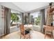 Sunlit dining area with hardwood floors and large windows, offering views of the landscaped backyard at 823 Timothy Dr, Longmont, CO 80503