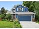 Charming two-story blue home with a well-manicured front lawn and a two car garage at 823 Timothy Dr, Longmont, CO 80503