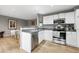 Bright, open-concept kitchen with stainless steel appliances and white cabinetry, flowing into the dining area at 823 Timothy Dr, Longmont, CO 80503