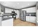 Modern kitchen featuring white cabinets, stainless steel appliances, and hardwood floors at 823 Timothy Dr, Longmont, CO 80503