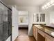 Well-lit bathroom featuring double sinks, granite counters, a walk-in shower, and a bedroom entrance at 23753 E Kettle Pl, Aurora, CO 80016