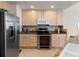 Modern kitchen featuring wooden cabinets, granite countertops, and stainless steel appliances at 23753 E Kettle Pl, Aurora, CO 80016