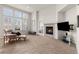 Cozy living room featuring plush carpet, a fireplace, and large windows for natural light at 23753 E Kettle Pl, Aurora, CO 80016