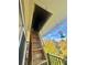 The attic access with a wooden ladder in front of a balcony with beautiful autumn-colored tree and blue sky at 491 S Kalispell Way # 305, Aurora, CO 80017