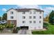 Rear view of the building featuring garage, well-kept lawn, and mature trees at 491 S Kalispell Way # 305, Aurora, CO 80017