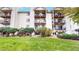 A three-story condo building with black metal balconies, green lawn, and trimmed shrubs at 491 S Kalispell Way # 305, Aurora, CO 80017