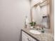Chic powder room features a granite counter, elegant mirror, and modern fixtures at 246 Ash St, Bennett, CO 80102
