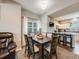 Dining area featuring a dark wood table, neutral chairs, and a view of the kitchen at 246 Ash St, Bennett, CO 80102