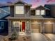 Charming two-story home with a red front door, inviting porch, well-manicured lawn, and attached garage, perfect for families at 246 Ash St, Bennett, CO 80102