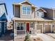 Attractive townhome with a red front door, cozy porch, maintained landscaping, and attached garage for convenient parking at 246 Ash St, Bennett, CO 80102