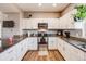 Well-lit kitchen with white cabinets, stainless appliances, and granite countertops at 246 Ash St, Bennett, CO 80102