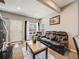 Comfortable living room features a leather sofa, bright windows, neutral paint, plush carpet, and a welcoming atmosphere at 246 Ash St, Bennett, CO 80102