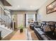 Cozy living room featuring a comfortable leather sofa, large windows, staircase, and neutral décor, perfect for relaxation at 246 Ash St, Bennett, CO 80102