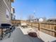 Backyard patio featuring a built-in fire pit, grilling area, and privacy fence at 246 Ash St, Bennett, CO 80102
