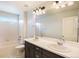 Bathroom featuring double sinks, a large mirror with lighting, and tiled shower and bathtub at 1018 Mcmurdo Cir, Castle Rock, CO 80108