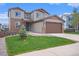 Two-story home featuring stone accents, a well-manicured lawn, and a large two car garage at 1018 Mcmurdo Cir, Castle Rock, CO 80108