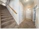 Staircase and entryway with light-colored carpeting at 5482 Wetlands Dr, Frederick, CO 80504