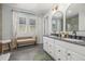 Bathroom featuring double sinks, modern fixtures, and a decorative bench at 3433 N Wabash St, Denver, CO 80238