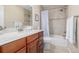 Well-lit bathroom with vanity, shower and tub combination, and neutral-toned tile at 3433 N Wabash St, Denver, CO 80238