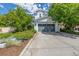Charming two-story home with a gray garage door, landscaped yard, and green trees at 3433 N Wabash St, Denver, CO 80238