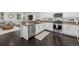 Well-lit kitchen featuring white cabinets, stainless steel appliances, and a convenient breakfast bar area at 3433 N Wabash St, Denver, CO 80238