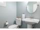 Updated half bath with a pedestal sink, decorative mirror, and modern fixtures at 3433 N Wabash St, Denver, CO 80238