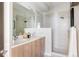 Modern bathroom with double sinks, a large shower, and light wood cabinets at 1836 Grove St # 107, Denver, CO 80204