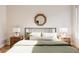 Bright bedroom with a green duvet, wood floors, and stylish nightstands at 1836 Grove St # 107, Denver, CO 80204