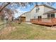 A spacious backyard features a wooden deck and a well-maintained lawn, enclosed by a rustic wooden fence at 1189 Fall River Cir, Longmont, CO 80504