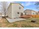 View of the back exterior of the house with a wood deck and concrete patio at 1189 Fall River Cir, Longmont, CO 80504